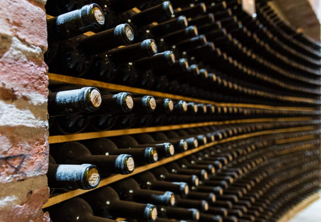 red wine bottles stored in a wine cellar of a winery